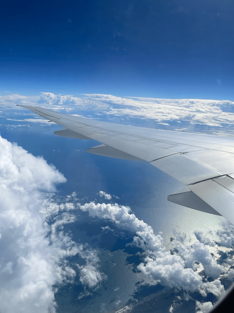 Looking out an airplane window above the clouds